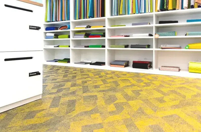 Acoustic modular carpet tiles in a woven vinyl grid pattern in an office